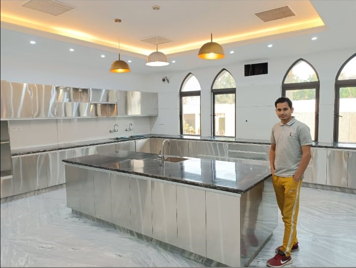 A spacious, modern kitchen with stainless steel fixtures, a large island, and arched windows letting in natural light.